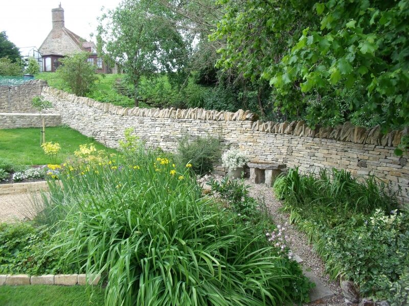 Restored terraced walled garden with dry stone walls and pond, Beckley