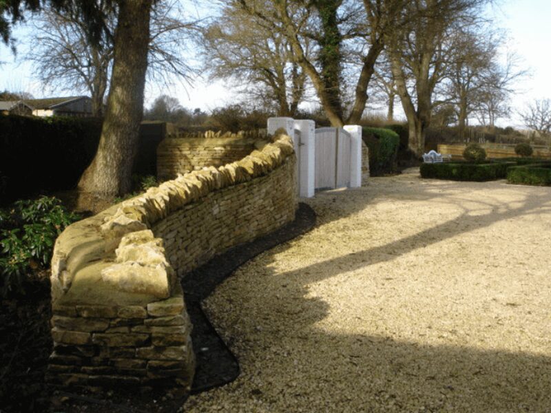 Serpentine sculptural dry stone wall casting long shadows