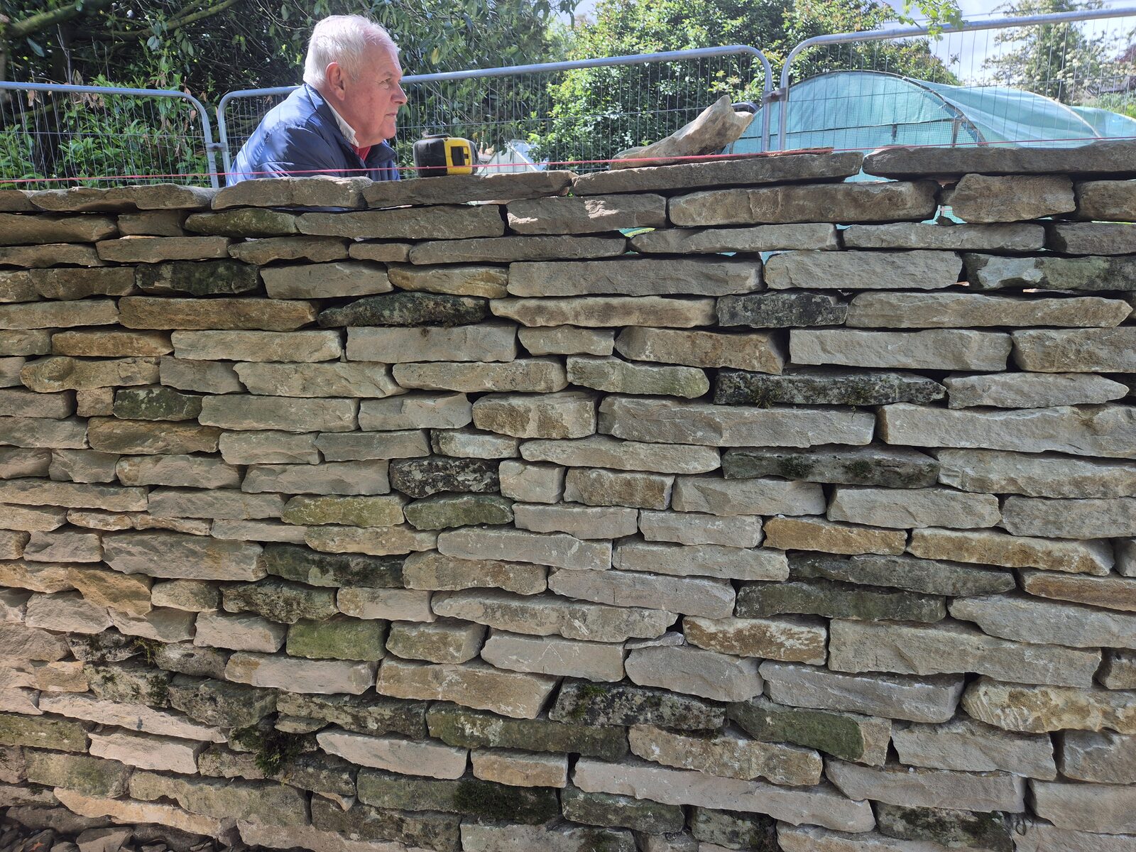 Close-up of fresh dry stone wall coursing during garden wall rebuild, Oxfordshire 2026