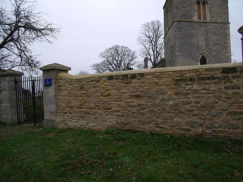 Restored churchyard dry stone wall at St Andrew's Oddington