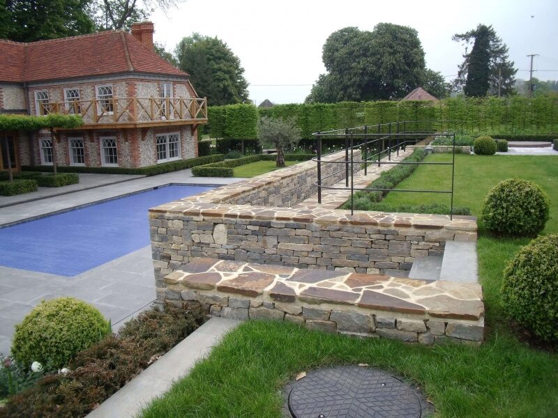 Purbeck dry stone retaining wall around a swimming pool terrace