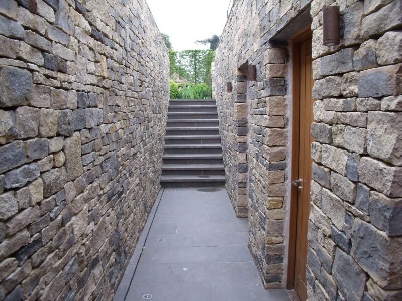 Dry stone walled passage in Purbeck stone with steps at a private Cotswold estate